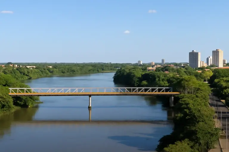 Vista aérea do Rio Parnaíba com ponte e skyline urbano de Teresina, Piauí, em um dia ensolarado com céu azul e vegetação ao redor