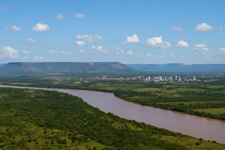 "Vista aérea do Tocantins com o Rio Tocantins em destaque, vegetação do cerrado e a cidade de Palmas ao fundo, cercada por planaltos
